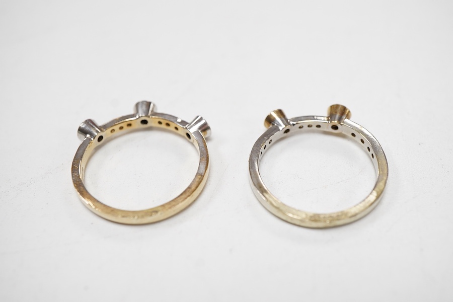 Two modern similar 14ct gold and diamond rings, one in yellow gold, with three collet set stones and six smaller stones, size P/Q, the other set in 9ct white gold, with two collet set stones and eleven smaller stones, si